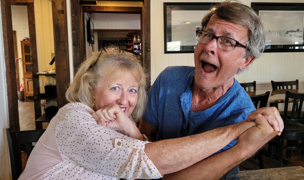 Retired couple in a restaurant with faces and emotions of fun and humility.